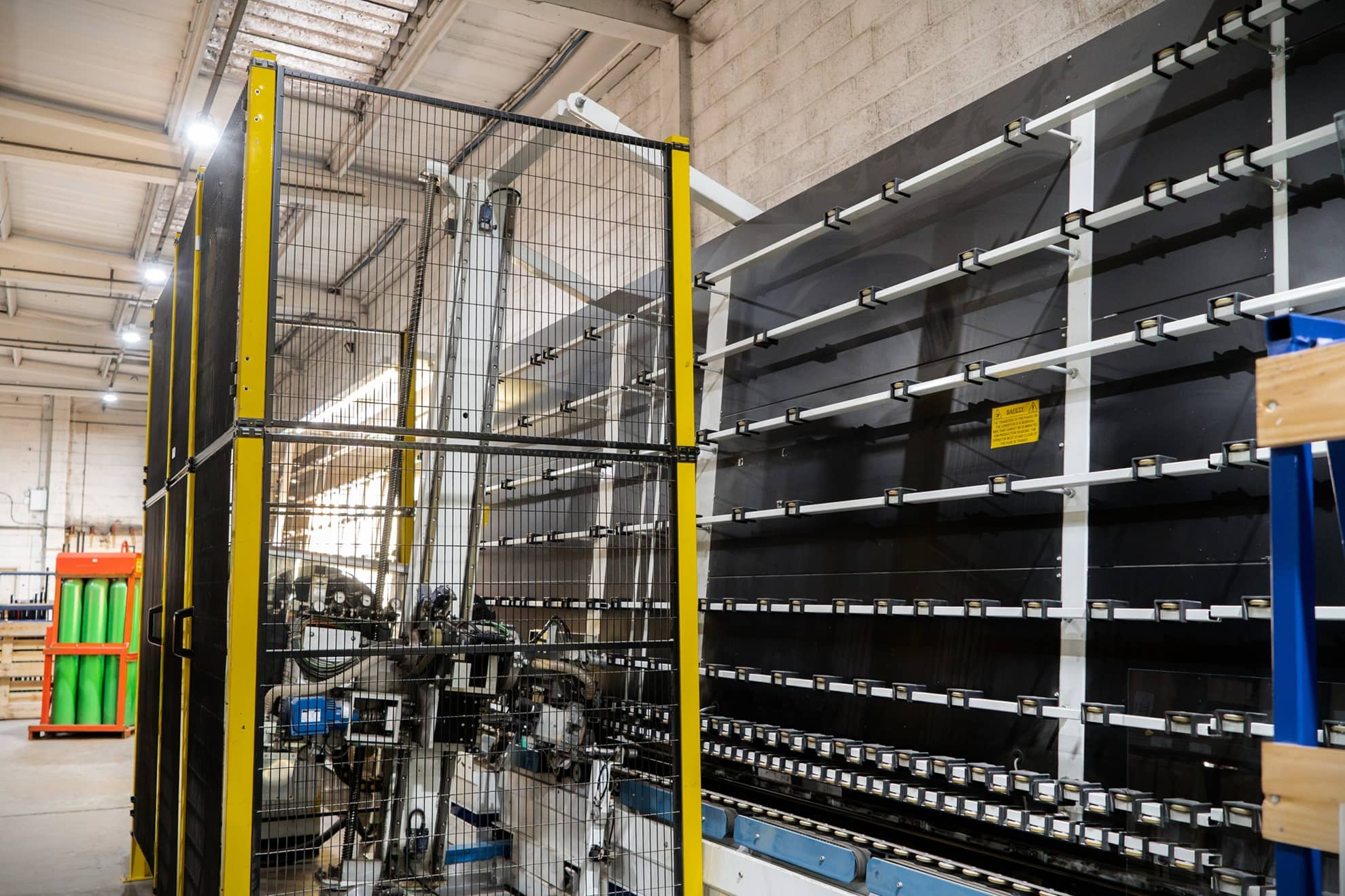 Automated IGU production line machinery with safety guarding at a double glazing manufacturer using warm edge spacer bar technology